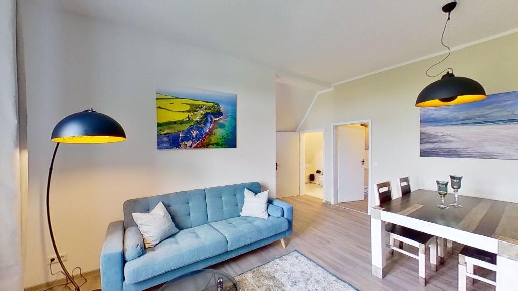 sala de estar con sofá azul y mesa en Ferienwohnung Leuchtturmwärter, en Putgarten