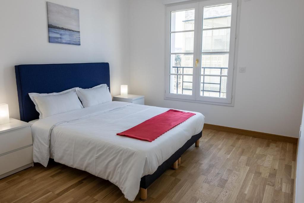 sypialnia z dużym łóżkiem z czerwonym kocem w obiekcie Villa Médicis Versailles Saint-Cyr-l'Ecole w mieście Saint-Cyr-lʼÉcole