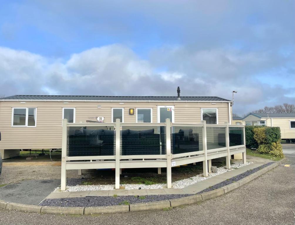 a mobile home with a fence in front of it at Trecco bay caravan hire 4 bedrooms sleeps 10 in Porthcawl