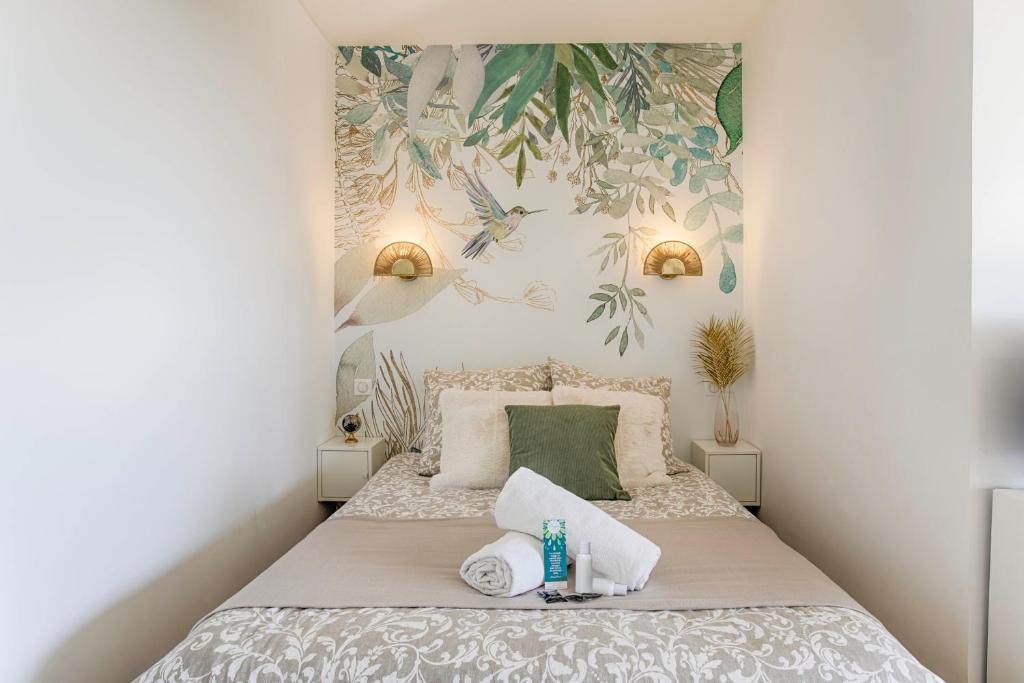 una piccola camera da letto con un letto e asciugamani di Appartement cosy avec vue imprenable sur Cabourg - accès direct plage - proche centre ville a Cabourg