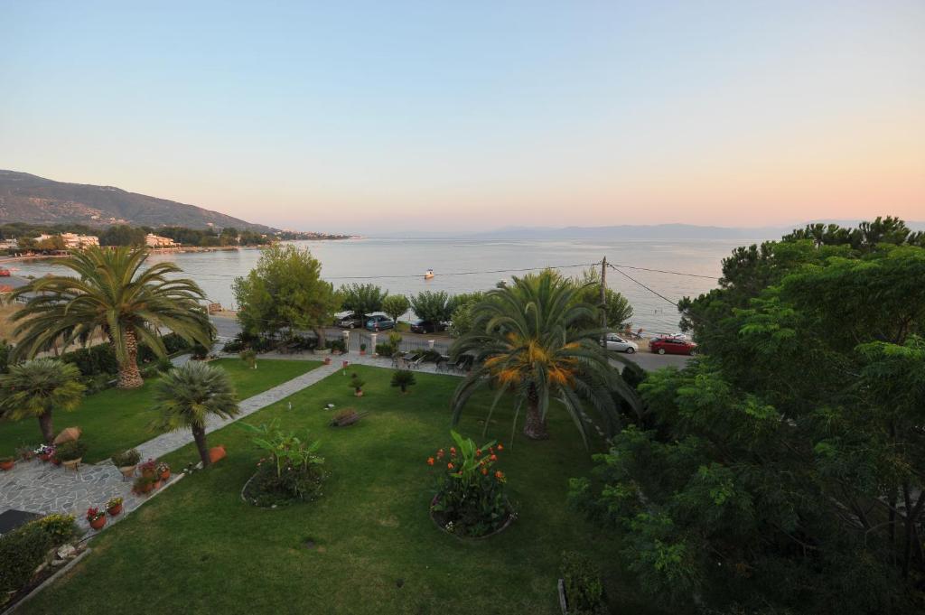 a view of a park with palm trees and the water at Galazia Akti in Agios Nikolaos