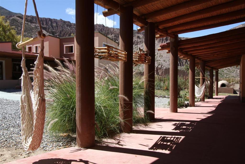 a covered walkway with a building and some grass at Mirador Del Virrey, Cabañas Boutique in Purmamarca