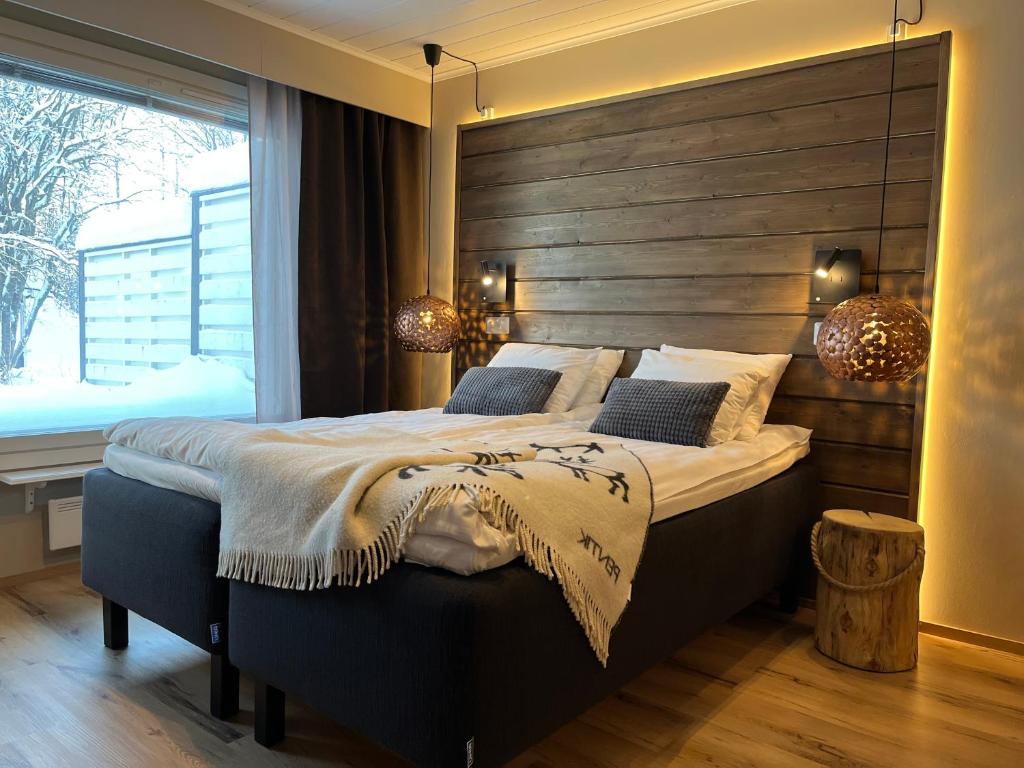a bedroom with a large bed with a wooden headboard at Townhouse with SAUNA&FREE PARKING close to Santa Claus Village & Santa Park in Rovaniemi