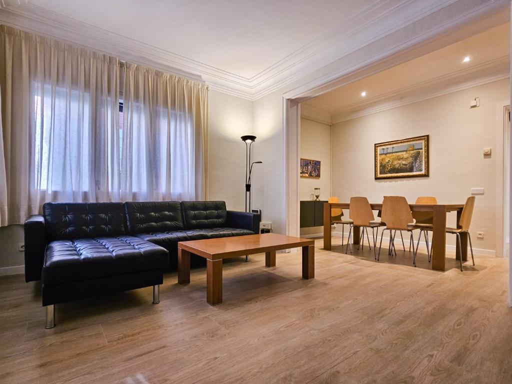 Classbedroom Park Güell Apartment في برشلونة: غرفة معيشة مع أريكة وطاولة