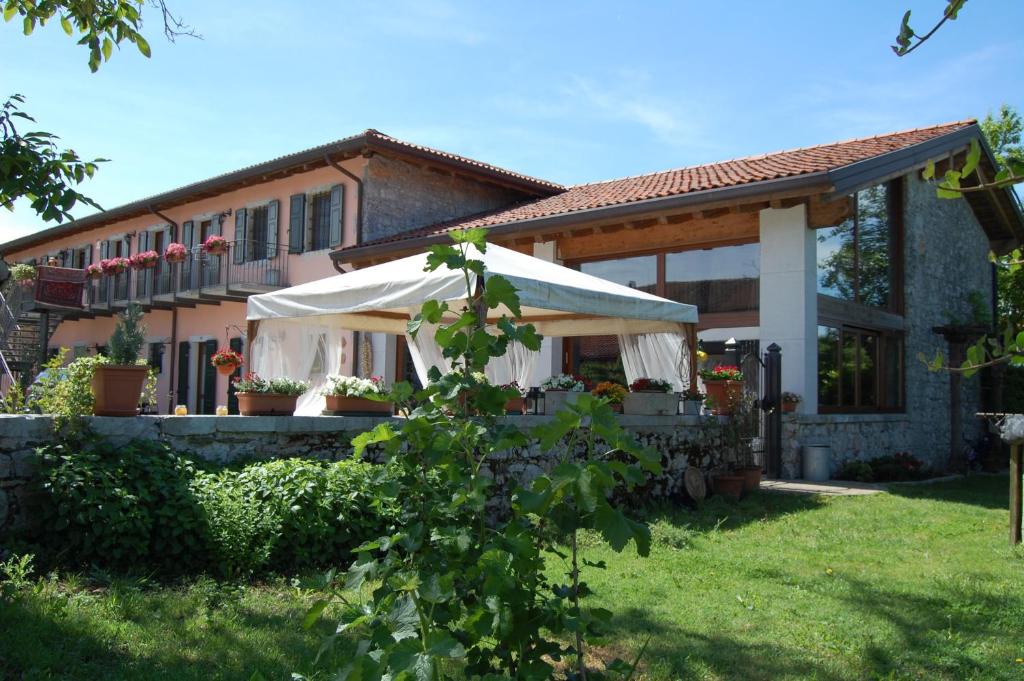 a house with a white awning in front of it at Agriturismo Borgovecchio in Romàns dʼIsonzo