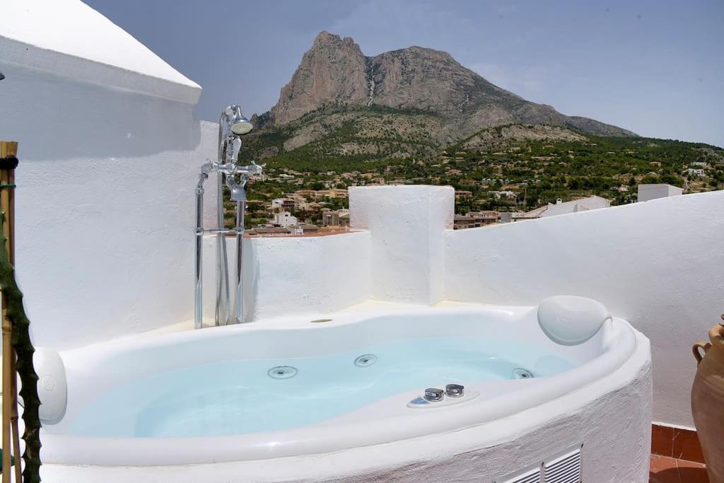 una vasca da bagno in una camera bianca con una montagna di La Campana de Finestrat a Finestrat