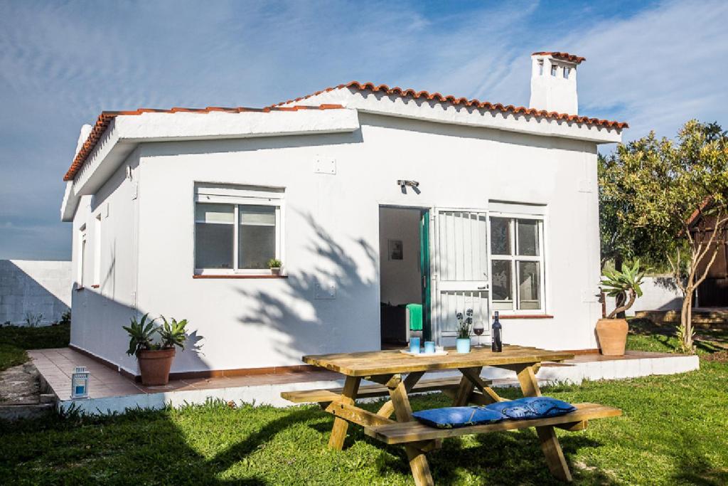 una casa blanca con una mesa de picnic delante de ella en BOLONIA HOUSE, en Tarifa