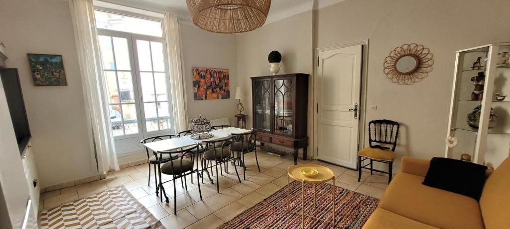 ein Wohnzimmer mit einem Tisch und Stühlen in der Unterkunft Le Rocher appartement Cotignac in Cotignac