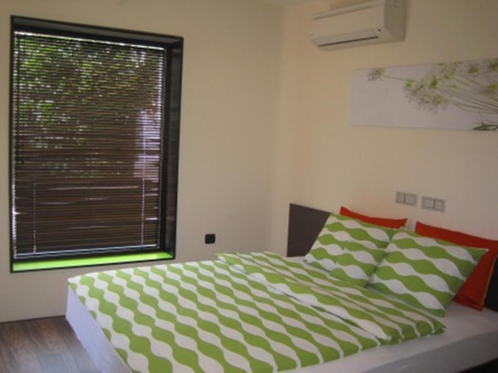 a bedroom with a bed and a large window at Apartment Alegria in Varna City