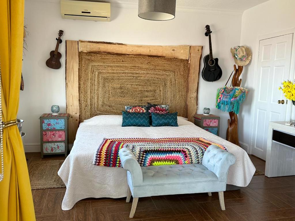 a bedroom with a bed and a chair and guitars at Tenerife Sur Habitación de Lujo in Adeje