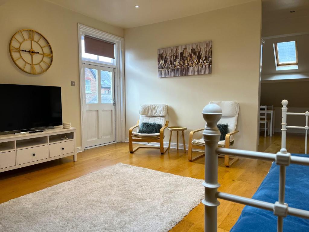 sala de estar con TV de pantalla plana y sillas en City Link - Mapperley Park Penthouse - Free parking,tram&bus,HSwifi,7ppl by KP en Nottingham