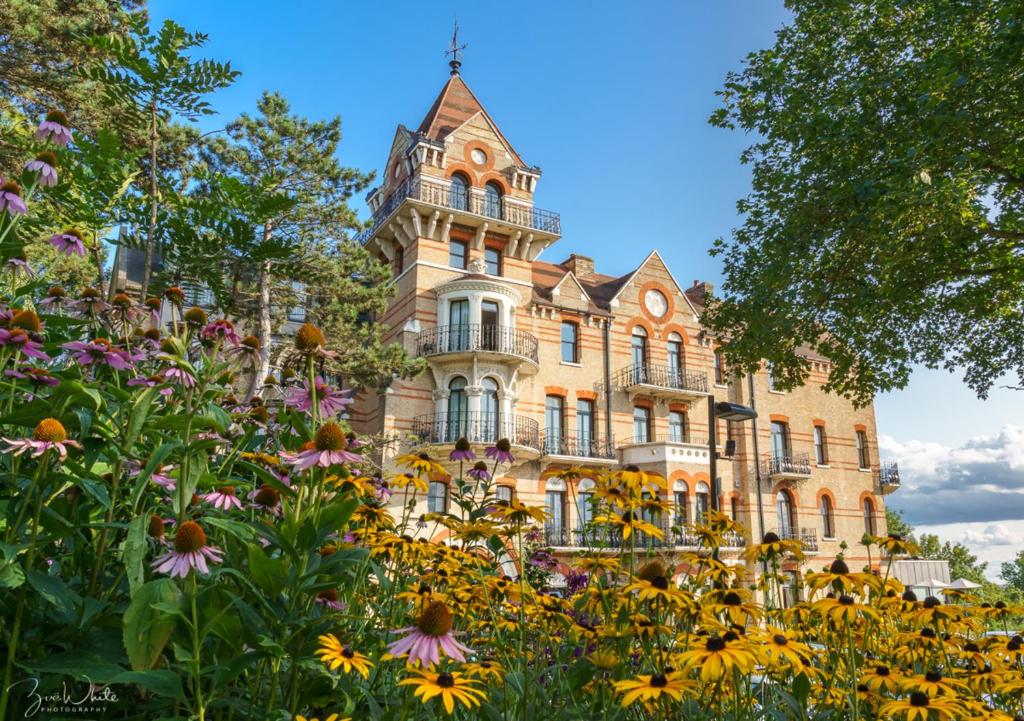 un vieux bâtiment avec des fleurs devant lui dans l'établissement The Petersham, à Richmond upon Thames