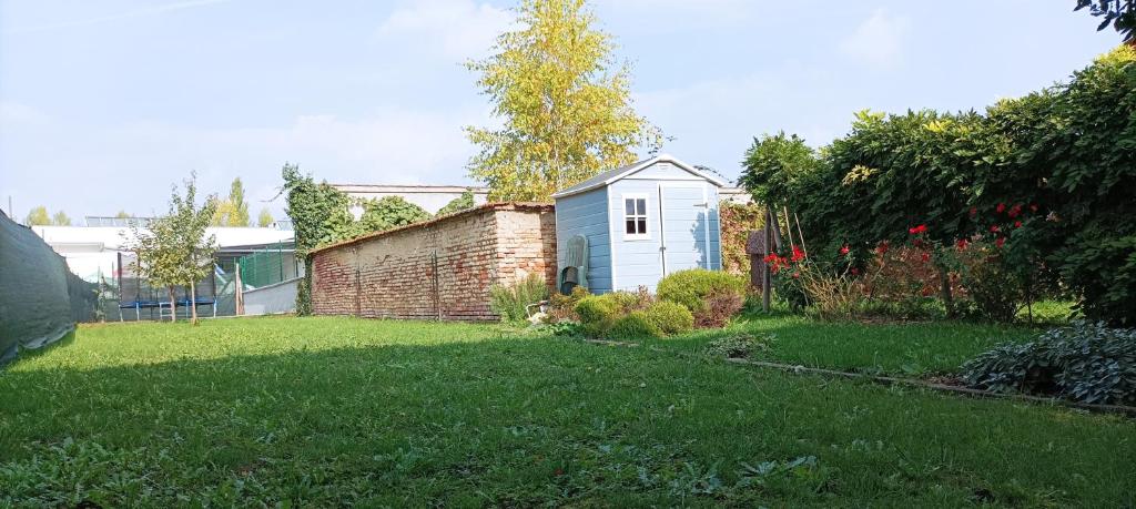 un cortile con un muro di mattoni e una casa di Quick Home - Casetta Blu a Gaglianico