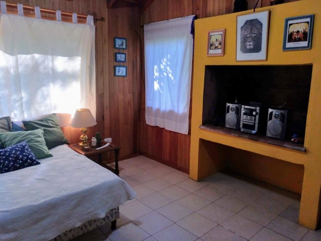 1 dormitorio con 1 cama y chimenea con 2 radios en Cabaña Los Helechos en San Martín de los Andes