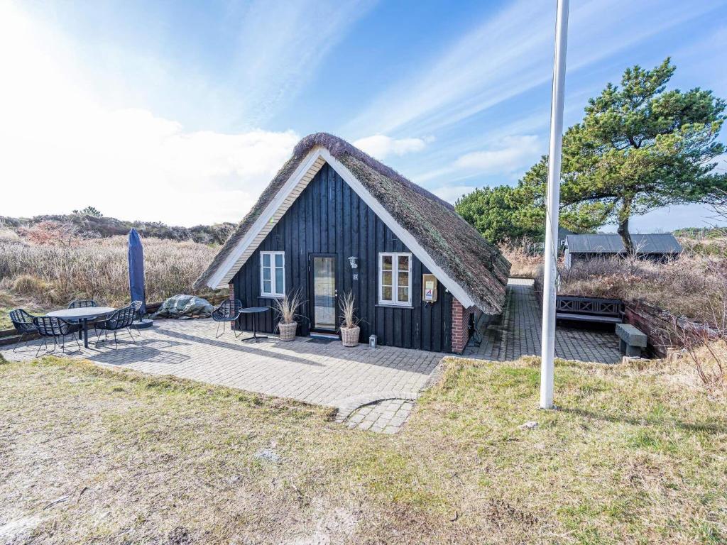 a small house with a thatched roof at Holiday home Henne CXXVIII in Henne Strand
