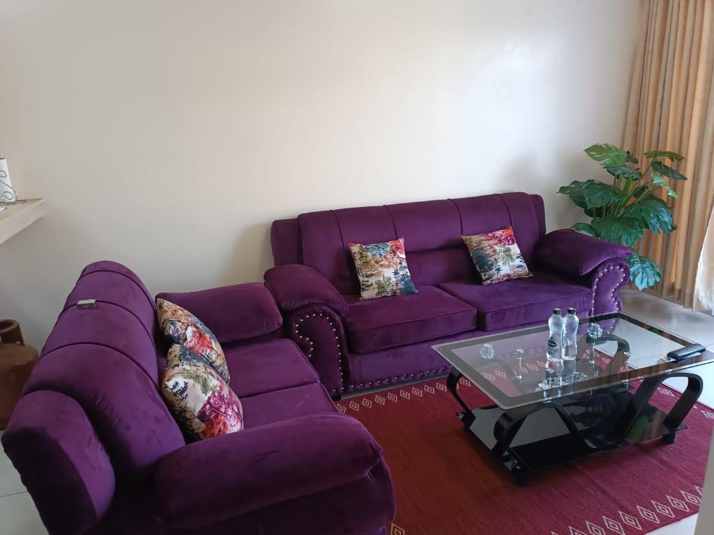 un soggiorno con divano viola e tavolino da caffè di Jojo's Ruaka Heaven a Ruaka