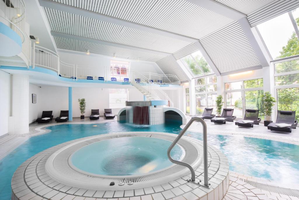 einen großen Pool mit Whirlpool in einem Gebäude in der Unterkunft Hotel Der Achtermann in Goslar