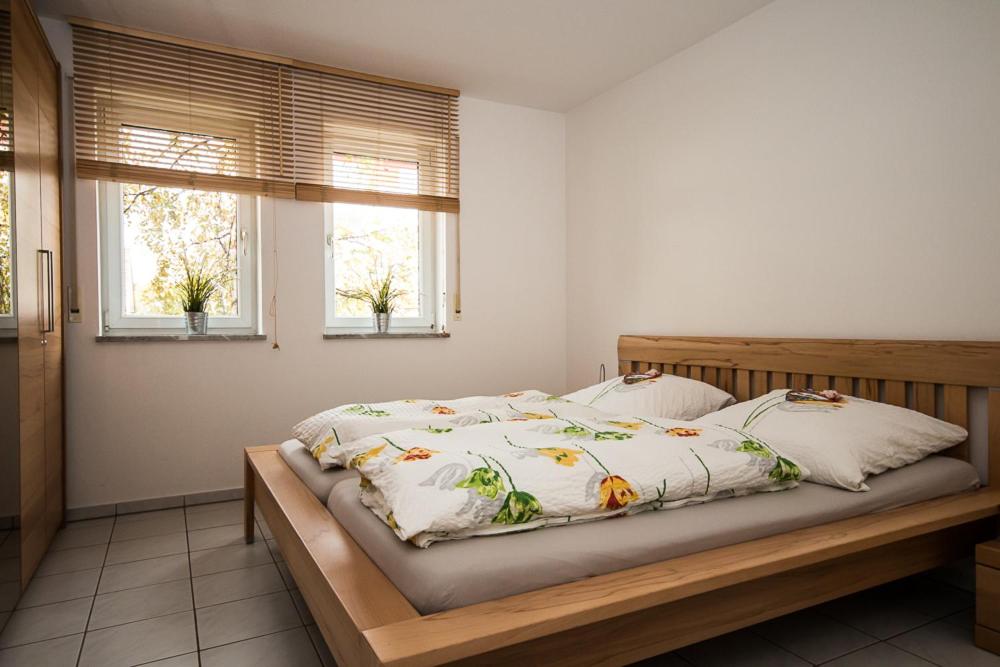 uma cama num quarto com 2 janelas em Ferienwohnung Bernhardt em Lindau