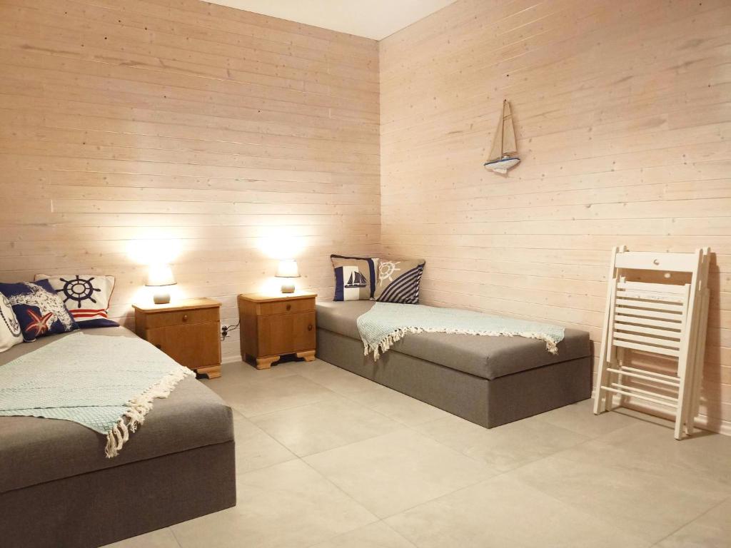 una camera con due letti, panca e lampade di Rybacki Domek 50 metrów do morza! a Dziwnów