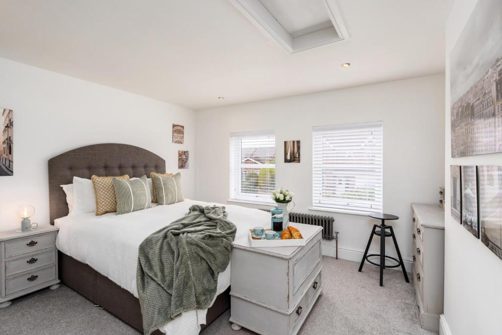 a bedroom with a bed and a desk and windows at The Laurel Cottage in Doncaster