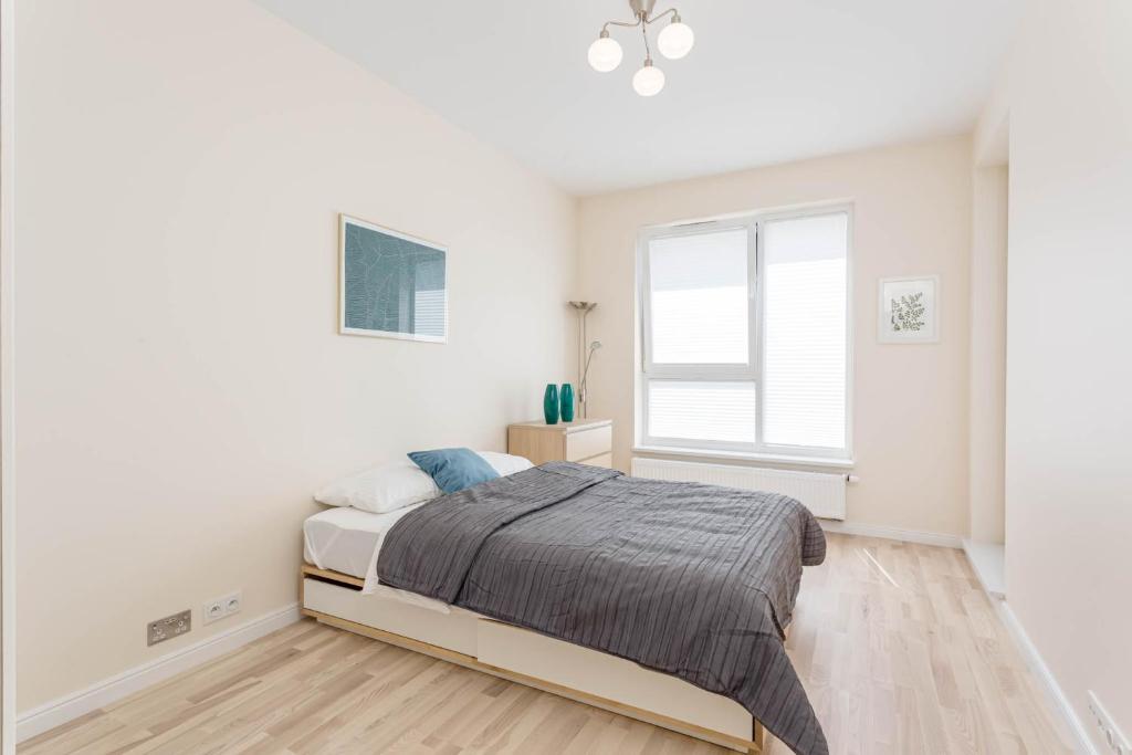 biała sypialnia z łóżkiem i oknem w obiekcie Chill Apartments Wilanów Business Center w Warszawie