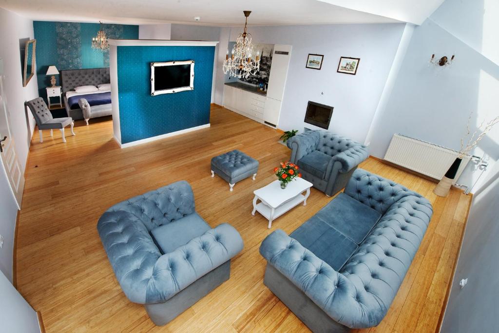 einen Blick über ein Wohnzimmer mit blauen Möbeln in der Unterkunft Hotel Mikołaj in Krakau