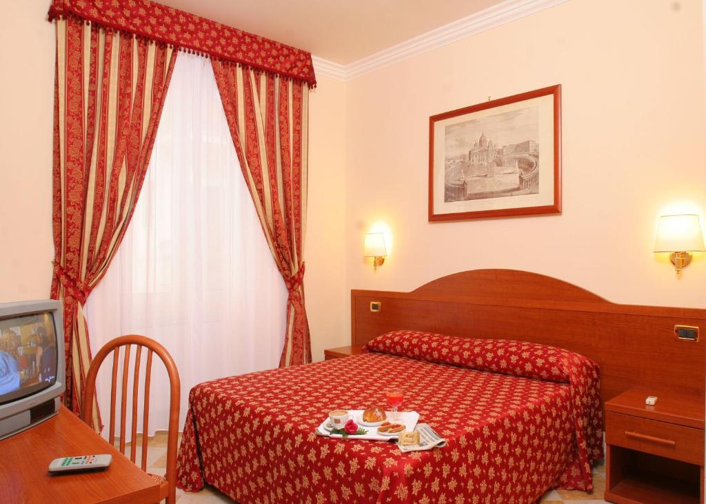 um quarto de hotel com uma cama e uma televisão em Hotel Chicago em Roma