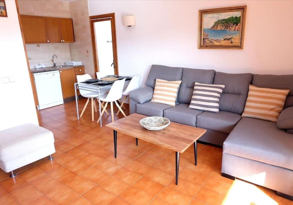 a living room with a couch and a table at Apartamento con piscina L' Áncora in Calella de Palafrugell