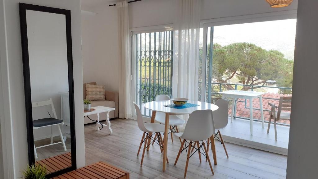 ein Esszimmer mit einem Tisch und Stühlen sowie einem Balkon in der Unterkunft Apartment Oli - Lloret de Mar in Lloret de Mar