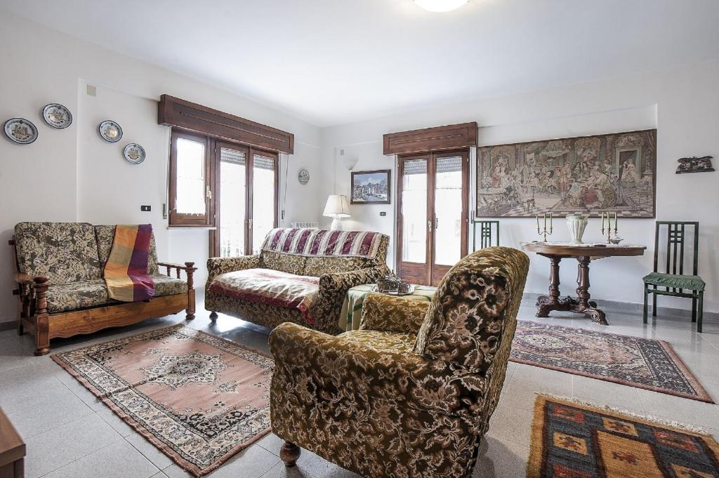 sala de estar con 2 sillas y sofá en Passiflora House - Basilicata en Sant’Angelo