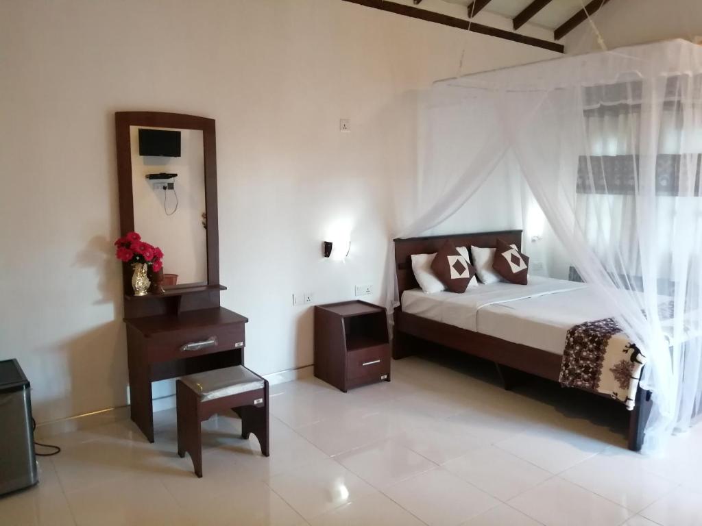a bedroom with a bed and a dresser and a mirror at Solitary Resort in Ella