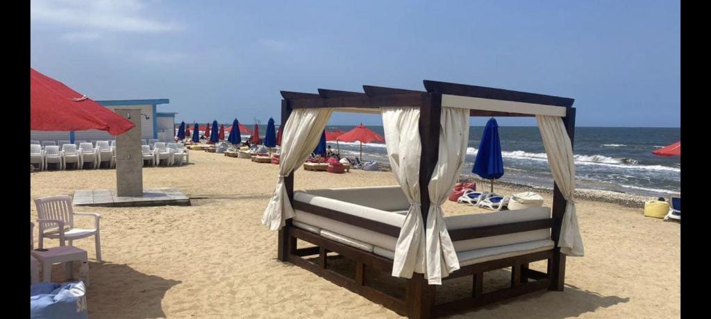 ein Bett am Strand mit Baldachin in der Unterkunft Porto Said Tourist Resort Luxury Hotel Apartment no390 in `Ezbet Shalabi el-Rûdi