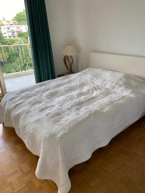 - un lit blanc dans une chambre avec fenêtre dans l'établissement NICE BAIE DES ANGES, à Nice