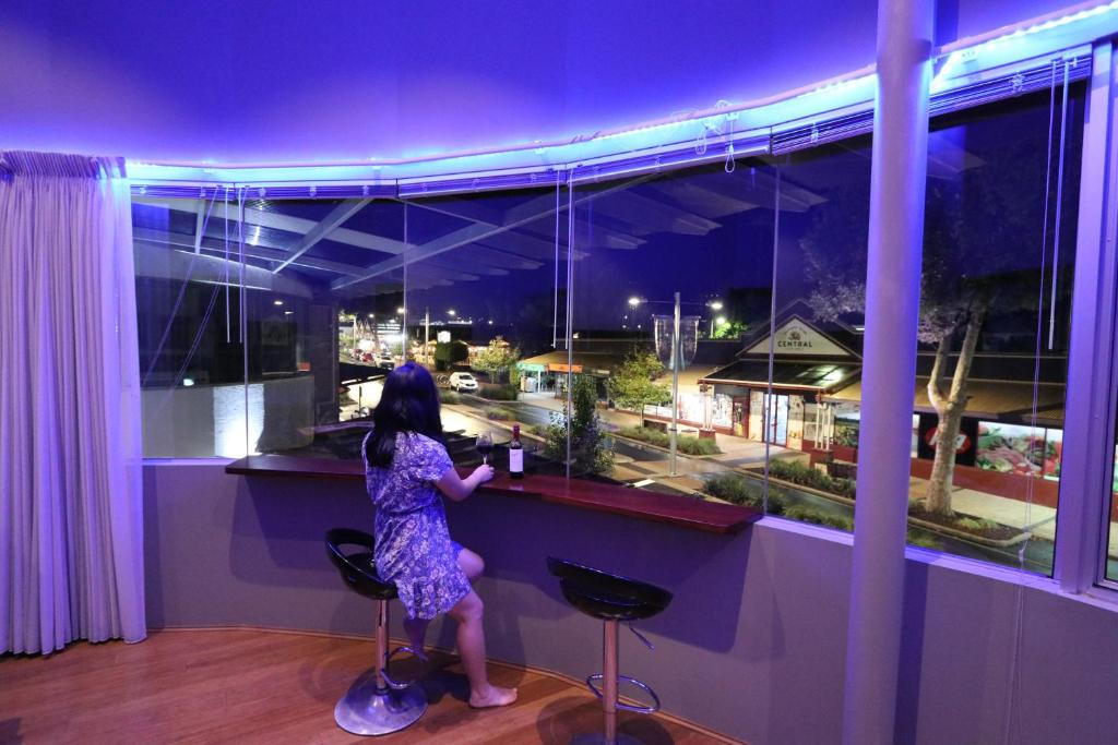 Una chica parada en un bar mirando por la ventana en Margaret River Mainstreet, en Margaret River Town