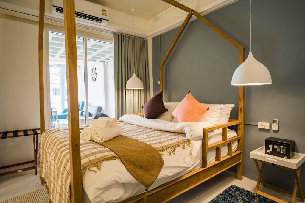 ein Schlafzimmer mit einem Himmelbett und Kissen in der Unterkunft Loft Comfy Stay Near Uni For Friends Family in Chiang Mai