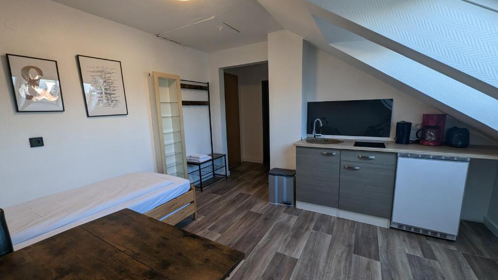 薩爾布呂肯的住宿－Europa City Apartment，一间卧室配有一张床,并在一间客房内配有电视。