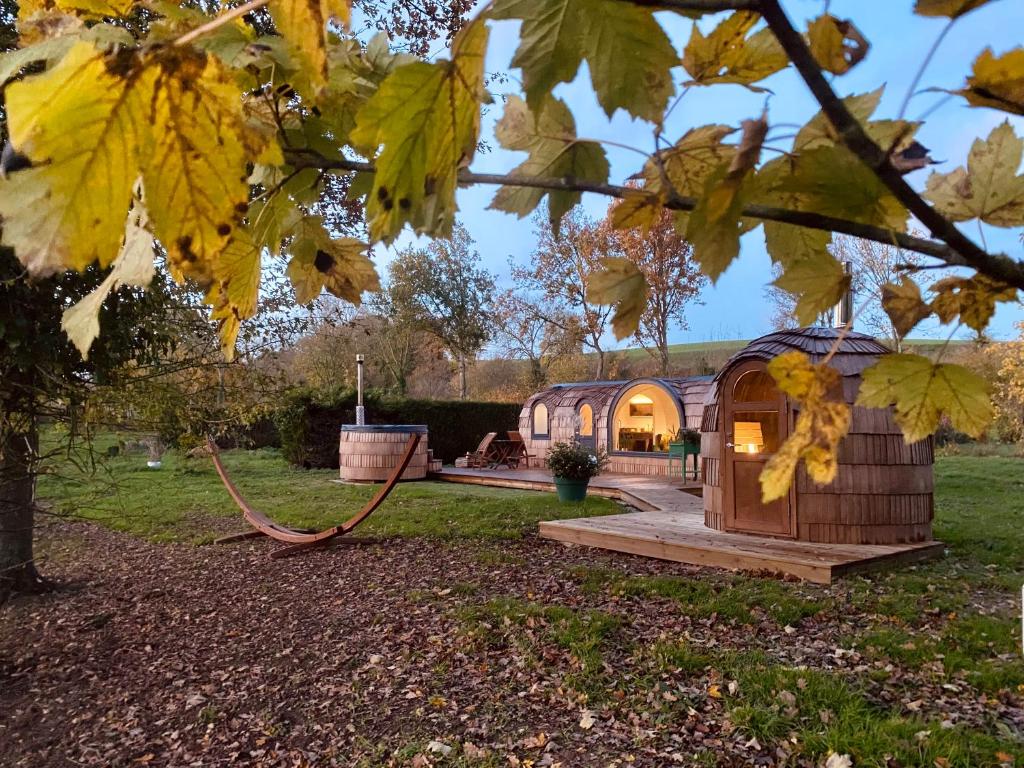 drewniany dom hobbita w ogrodzie z oświetlonymi drzwiami w obiekcie Au Vieux Moulin w mieście Roy-Boissy