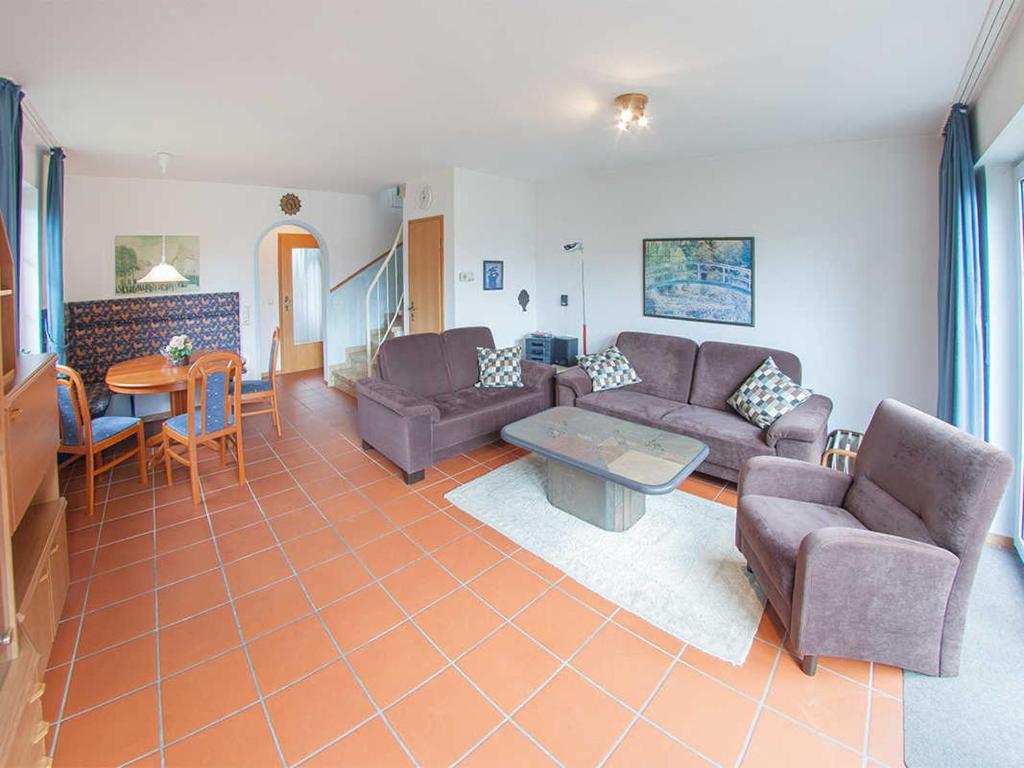 - un salon avec un canapé et une table dans l'établissement Ferienhaus Wattwurm 1, FeWo Vermittlung Nordsee, à Dangast