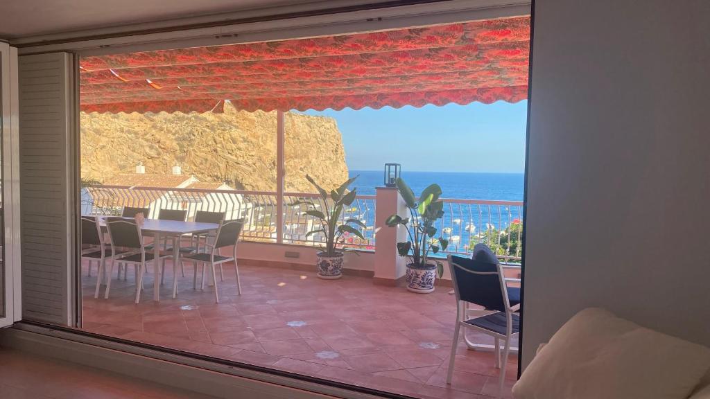 un comedor con vistas al océano desde una ventana en Apartamento Embarcadero de Calahonda, en Calahonda