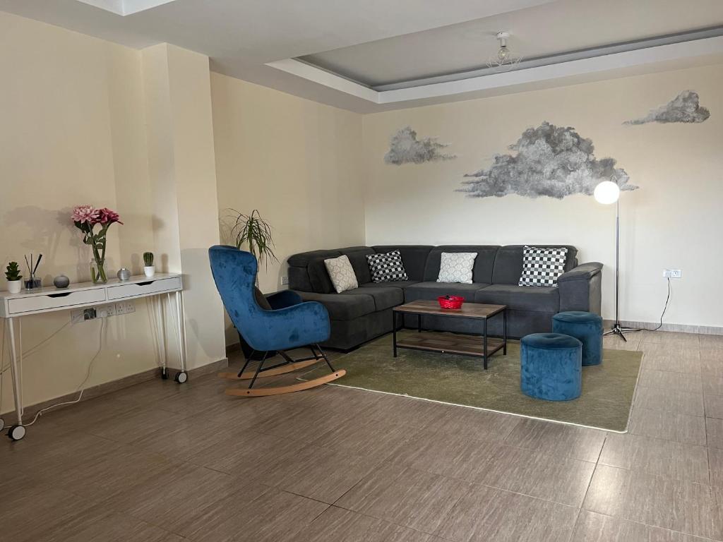 - un salon avec un canapé et un fauteuil bleu dans l'établissement Chioni Cottage by AgroHolidays, à Kyperoúnta
