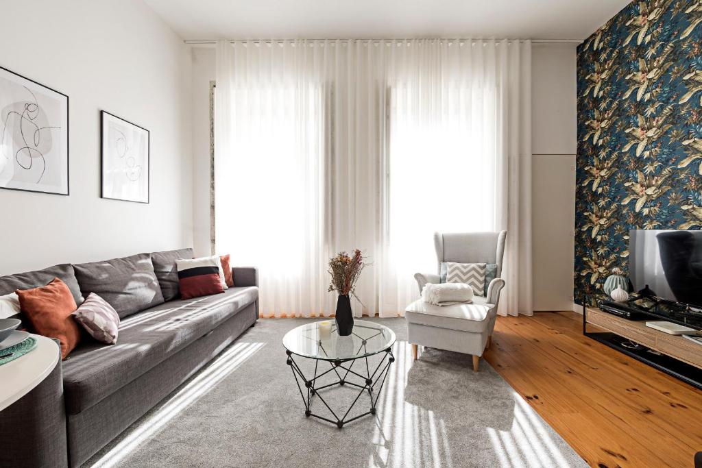 a living room with a gray couch and a table at LovelyStay - Cativo Studio Downtown by Metro Station in Porto