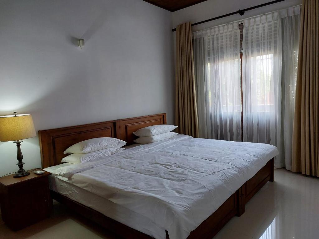 - une chambre avec un lit, une lampe et une fenêtre dans l'établissement Comfy Home near the town, à Maharagama