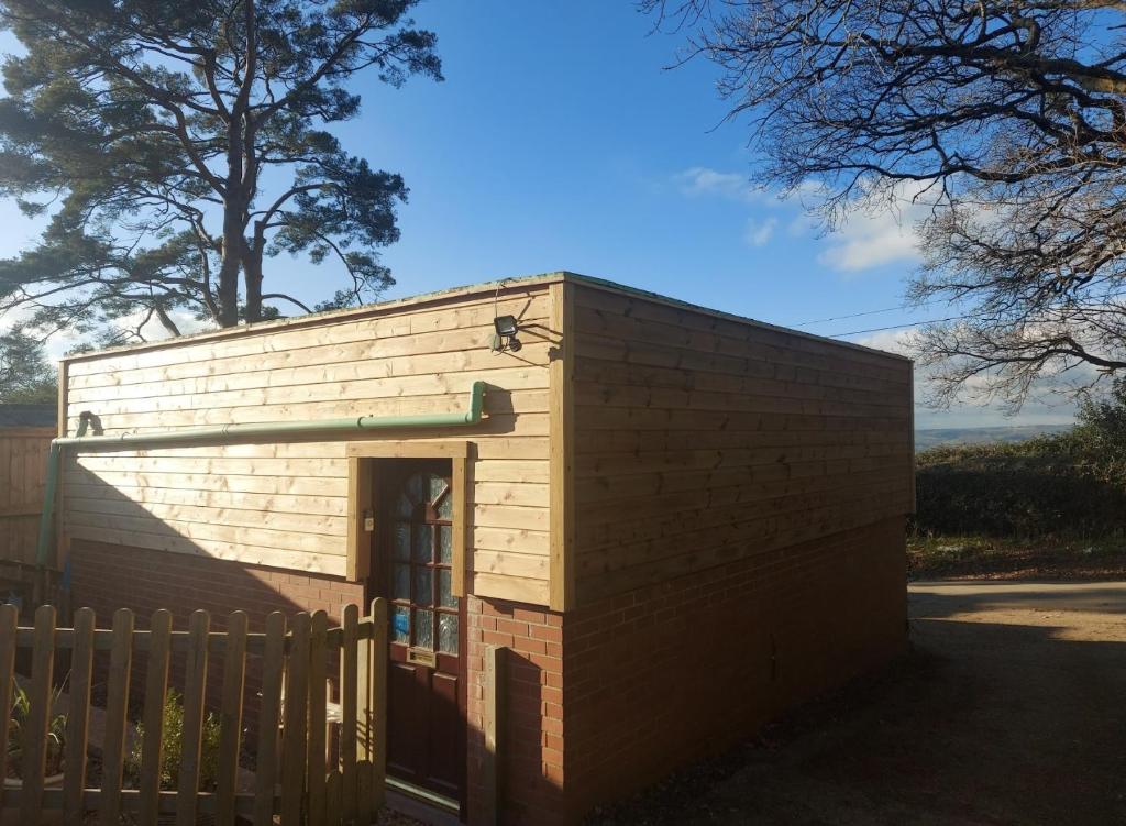 een klein bakstenen gebouw met een poort en een hek bij Studio Near Lyme Regis, Dog Friendly, Self Catering, Small Garden, Free Private Parking" in Axminster