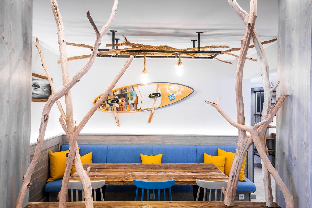 a dining room with a wooden table and a surfboard on the wall at Bude54 in Sankt Peter-Ording