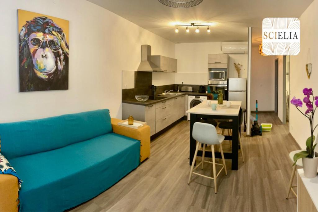 uma sala de estar com um sofá azul e uma cozinha em Chez Françoise em Porto Ota