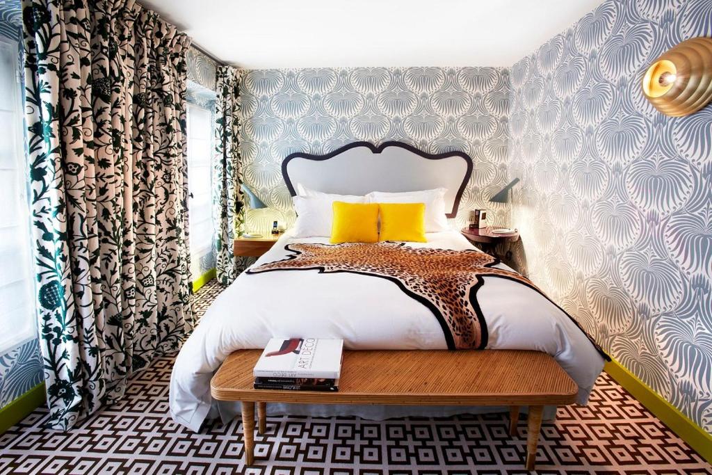 a bedroom with a bed and a table with a book at Hôtel Thoumieux in Paris