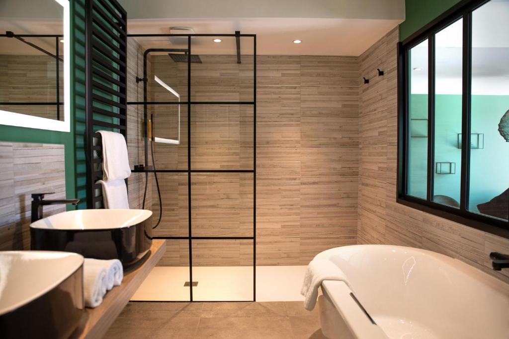 a bathroom with a tub and a sink at Manoir le Roure in Châteauneuf-du-Rhône