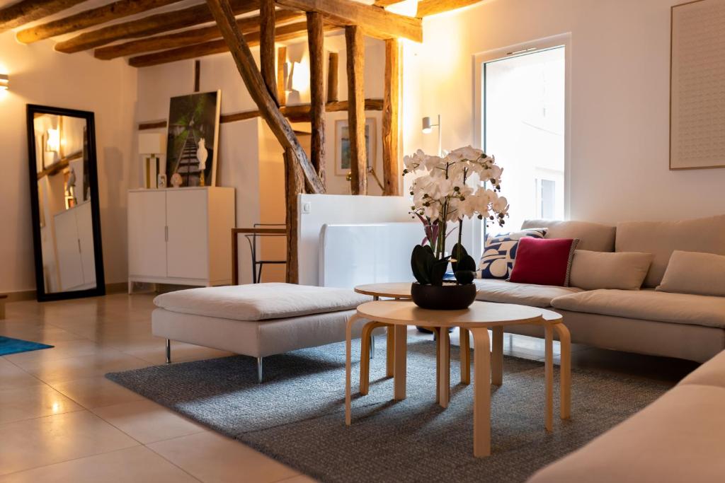 ein Wohnzimmer mit einem Sofa und einem Tisch in der Unterkunft La Maison Coco à 8min de Disneyland Paris in Montévrain