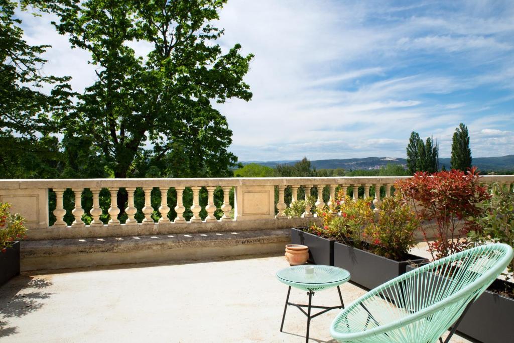 two green chairs and a table on a patio at Manoir le Roure in Châteauneuf-du-Rhône