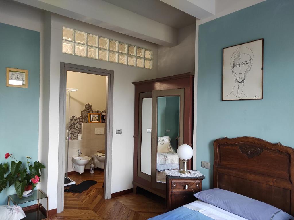 een slaapkamer met een bed en een spiegel en een badkamer bij Tetto alle Rondini in Cuneo